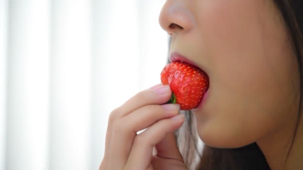 Ázsiai csinos nő gazdaság és eszik friss eper piros bogyó gyümölcs színe és édes lédús élvezettel és boldog érzelmek koncepció élelmiszer, egészséges táplálkozás az életben (Lassú mozgás) - Felvétel, videó