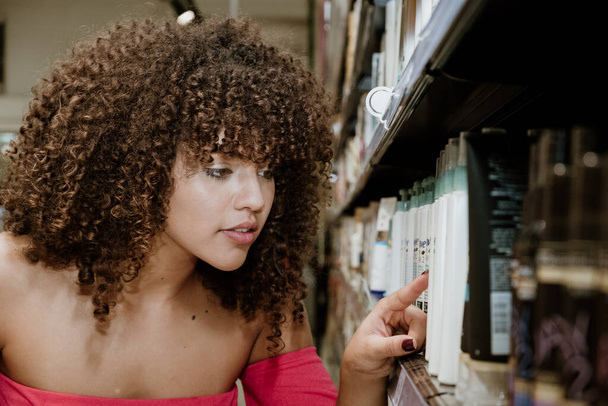 若いブラジル巻き女性店で買い物をする - 写真・画像