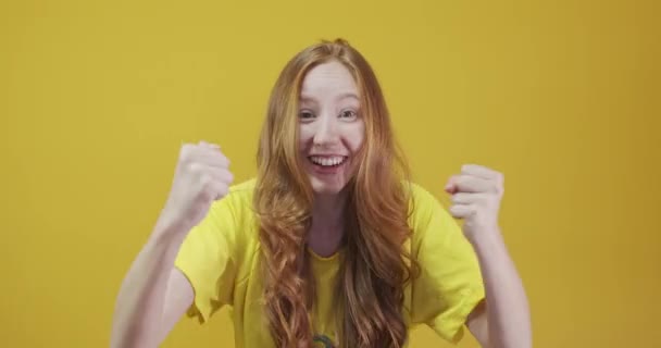 Ruiva jovem mulher posando gestos no fundo amarelo
 - Filmagem, Vídeo