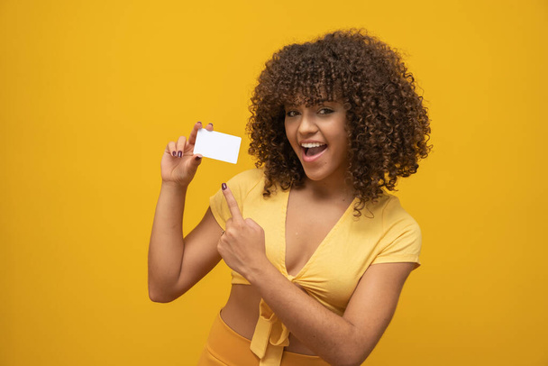 Young latin curly woman posing on bright yellow background - Foto, immagini
