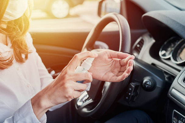 Kuljettajan desinfiointi kädet antibakteerinen puhdistusaine autossa ennen ajamista. Koronaviruksen ennaltaehkäisevä toimenpide
 - Valokuva, kuva