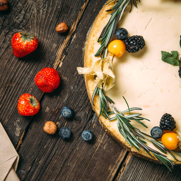 Pastel de queso dulce con bayas y romero
 - Foto, imagen