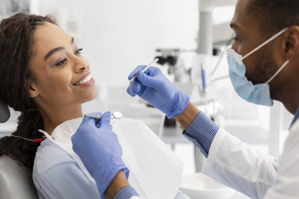 Afrykanka uczęszczająca do dentysty, lekarz prowadzący badania - Zdjęcie, obraz