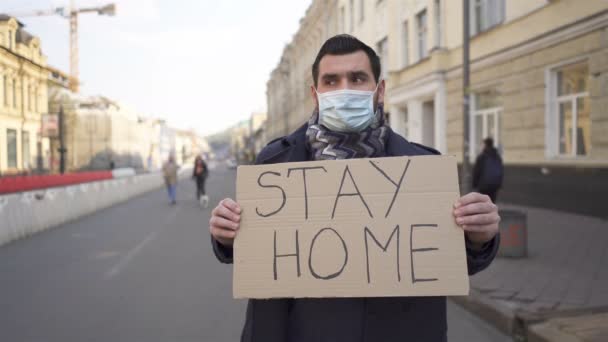  Uomo in maschera medica stand con poster sulla strada della città. Squadra pandemica Word
 - Filmati, video