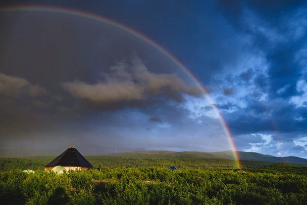 Altai Cumhuriyeti, Rusya 'nın Ongudaysky bölgesindeki gökkuşağının altındaki geleneksel altai evi ve turist çadırlarına selam olsun. - Fotoğraf, Görsel