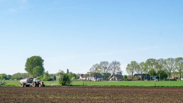 Tractor stands in a typical Dutch farm landscape in a Dutch polder landscape - Photo, Image