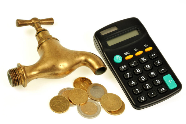Concepto de factura de agua con un grifo junto a una calculadora y monedas sobre un fondo blanco
 - Foto, Imagen