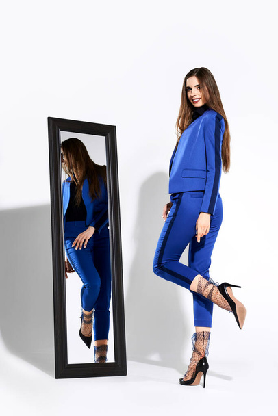 Stylish girl posing in pantsuit and tulle socks near the mirror - Fotografie, Obrázek