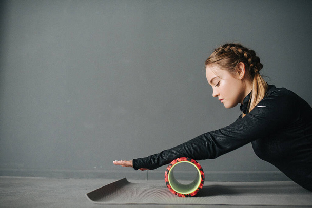 Femme sportive caucasienne étirant les muscles en séance d'entraînement en studio pilates. Définir la photo avec prise de vue film
. - Photo, image