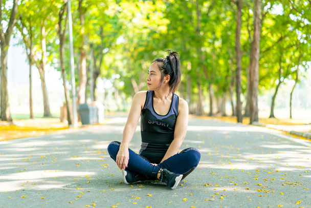 Asian woman sitting and relax after exercise at park - Фото, зображення