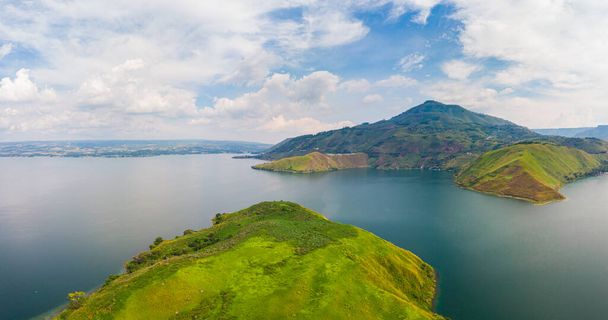 Aérea: lago Toba y Samosir Island vista desde arriba Sumatra Indonesia. Enorme caldera volcánica cubierta por el agua, pueblos tradicionales Batak, arrozales verdes, bosque ecuatorial. - Foto, Imagen