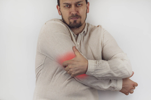 Arthritis concept. Man has elbow pain, highlighted in red, cropped - Photo, Image