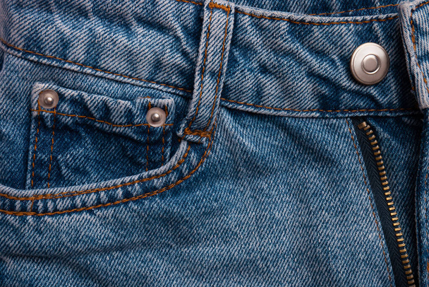 Blauwe jeans met pocket als achtergrond. Macro view van nieuwe jeans broek met details. Bovenaanzicht - Foto, afbeelding