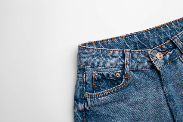 Calça jeans azul no fundo branco. Vista superior de calças jeans com espaço para texto
 - Foto, Imagem