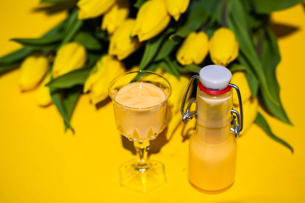 Eggnog with yellow tulips on a yellow background - Zdjęcie, obraz