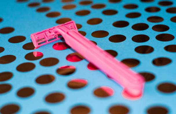 Яскравий фон з конфетті і рожевою жіночою бритвою. Радіатор для гладкого гоління. Гострі бритви для особистої гігієни
. - Фото, зображення