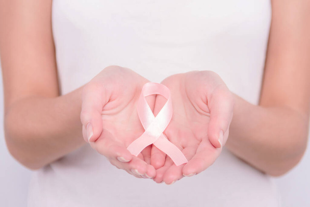 Onkológiai betegség koncepció. Fehér felsős lány rózsaszín szalaggal a kezében a mellrák szimbólumaként.. - Fotó, kép
