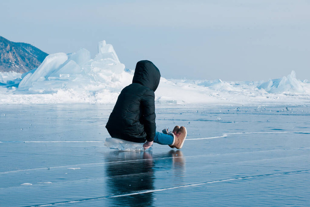 Egy lány magasról nézi a Bajkál-tó jegét. - Fotó, kép