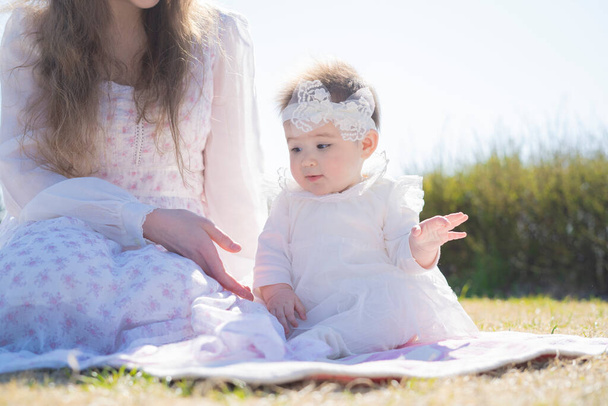 Jeune mère caucasienne et bébé portant une corolle jouant dans le parc
 - Photo, image