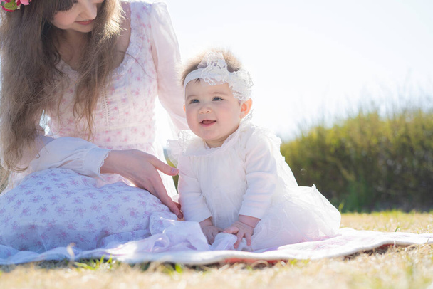 Jovem mãe branca e bebê vestindo corolla brincando no parque
 - Foto, Imagem