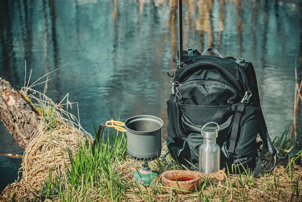 森の川で釣り。バックパック付きのハイキング中の料理. - 写真・画像