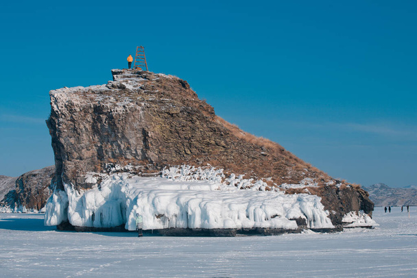Un homme vêtu d'une veste jaune est monté sur une île, le lac Baïkal
 - Photo, image