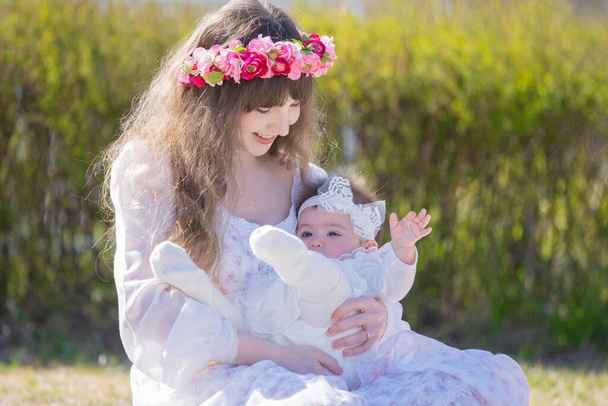 Jeune mère caucasienne et bébé portant une corolle jouant dans le parc
 - Photo, image
