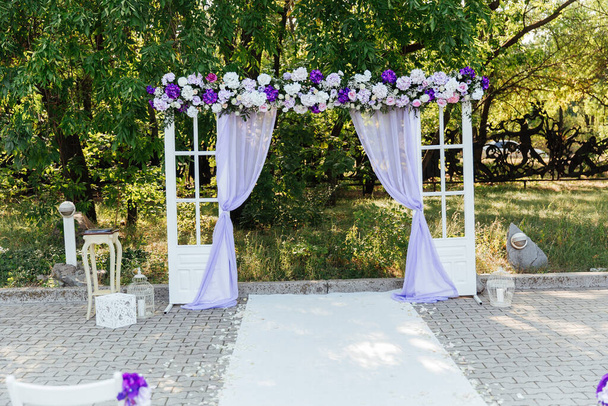 wedding decor at a visiting ceremony, a wedding arch of white color with violet flowers - Photo, Image