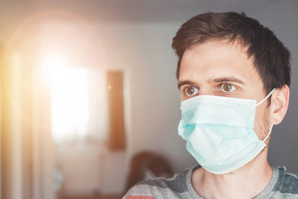 Young man indoor wearing a face mask, portrait. Corona and flu season. - Φωτογραφία, εικόνα