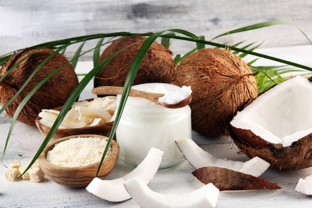 Kokosové výrobky s čerstvým kokosem, kokosové vločky, kokosový lázeňský olej. Zralé kokosové plody - Fotografie, Obrázek