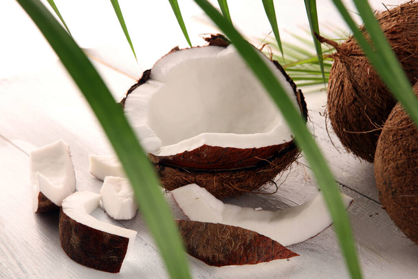 Tuore raaka kookos palmunlehdillä taustalla. Kypsät kookoshedelmät
 - Valokuva, kuva