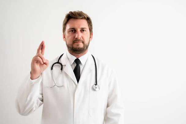 Portret męskiego lekarza ze stetoskopem w mundurze medycznym pokazujący szczęście pozowania na białym, izolowanym tle - Zdjęcie, obraz