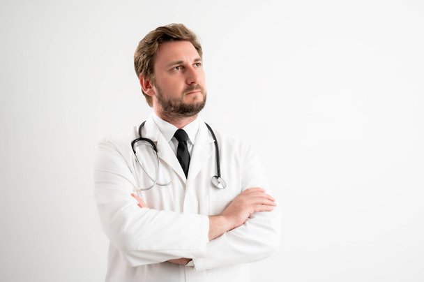 男性医師の肖像とともに聴診器で医療制服見て確信ヒーローショットポージング上のホワイト隔離された背景 - 写真・画像