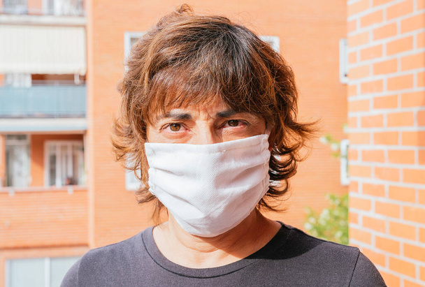 Donkerharige vrouw met masker tegen Coronavirus, Covid - 19 of enige andere ziekte op straat - Foto, afbeelding