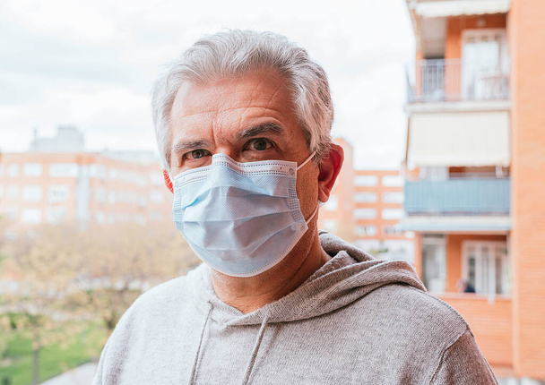 Старший біловолосий чоловік у масці проти Коронавіруса, Ковід - 19 або будь-яка інша хвороба, на вулиці - Фото, зображення
