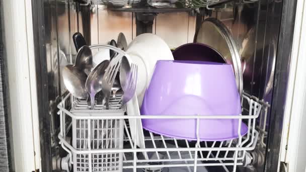 Usando uma máquina de lavar louça moderna na casa, as mãos da dona de casa tiram pratos limpos da máquina de lavar louça, de perto. Eletrodomésticos modernos em casa. Vídeo 4K
 - Filmagem, Vídeo