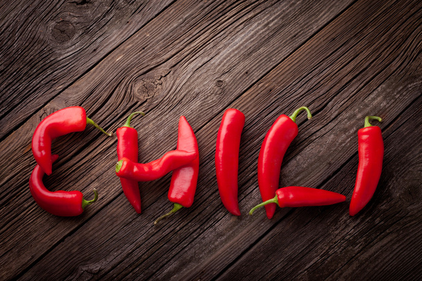 Chili sign with fresh chillies on a wooden table - Fotografie, Obrázek