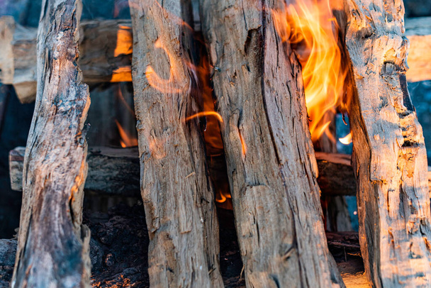 Zbliżenie odkryty fotografia płonącego, ognistego płonącego drewna w ognisku z jasnym gorącym czerwonym i pomarańczowym ogniem płomienie i żar - Zdjęcie, obraz