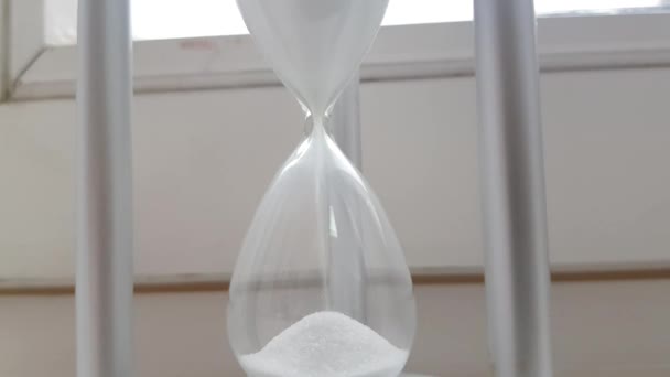 Reloj de arena en el fondo de la ventana, símbolo del paso del tiempo, vídeo 4K
 - Imágenes, Vídeo