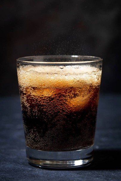 Coca Cola with ice in a glass on a dark background, closeup - Foto, Imagem