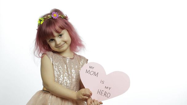 Lapsi tyttö prinsessa pitää vaaleanpunainen paperi sydän tekstiä äidistä. Äitienpäivä
 - Valokuva, kuva