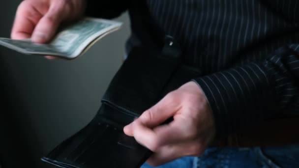 Homme d'affaires comptant des dollars d'argent dans son portefeuille. Vue rapprochée des mains masculines compter les dollars. Peu d'argent, concept de faillite, crise économique
 - Séquence, vidéo
