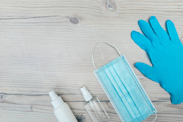 protective mask, gloves and antiseptics on a wooden background - Photo, Image