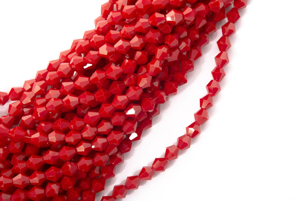 Hermosas perlas de cristal espumado de cristal rojo sobre fondo blanco. Uso para joyería de cuentas de bricolaje
 - Foto, imagen