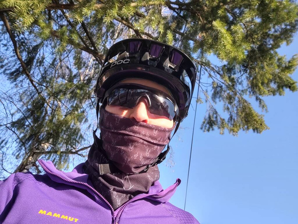 Radfahrerin mit Helm und Sonnenbrille in der Atemschutzmaske in der Natur. Slowakei - Foto, Bild