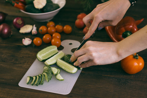 jovem mulher cortando legumes saudáveis
 - Foto, Imagem