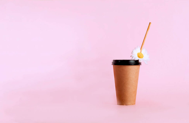 Coffee in disposable paper cup with wooden tube on pink pastel background.The concept of modern ecology. Zero Waste vs Covid-19. Copy space, close-up - Photo, Image