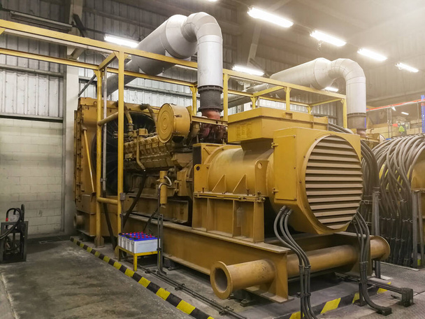 Erittäin suuri sähköinen dieselgeneraattori tehtaalla hätätilanteessa, laitetehdas moderni teknologia industria
 - Valokuva, kuva