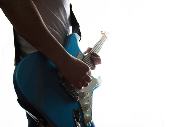 Medium shot van de mens spelen een blauw-wit elektrische gitaar - Foto, afbeelding