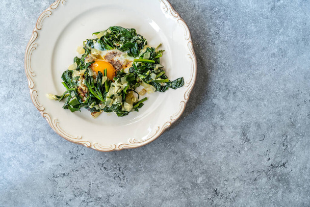 Homemade Cooked Spinach with Fried Egg in Plate. Healthy Organic Hot Food. - 写真・画像